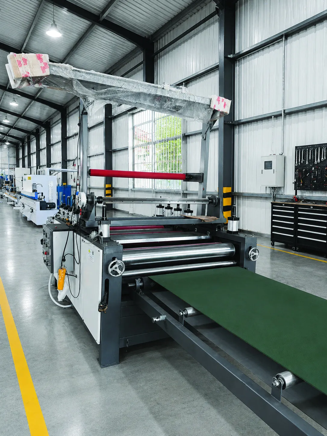 Máy gia công có trục lăn và băng tải màu xanh